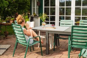 femme lisant un livre dehors sur le patio