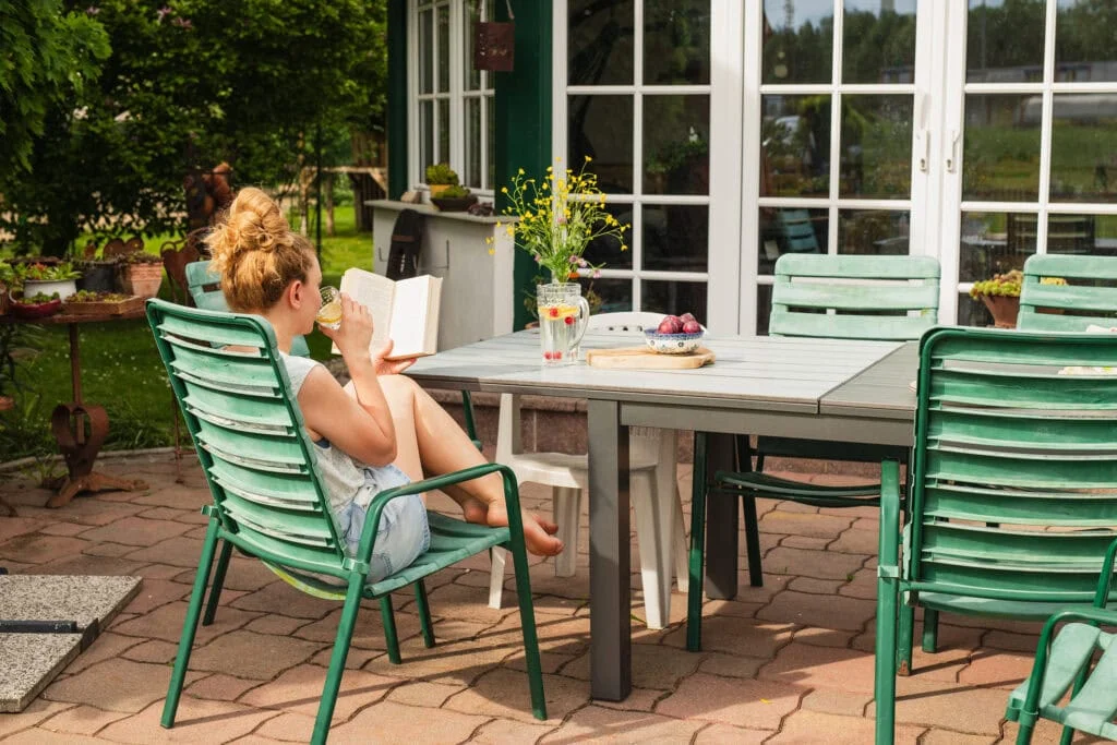 femme lisant un livre dehors sur le patio