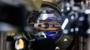 A close up of a laser table with lasers and mirrors on it.