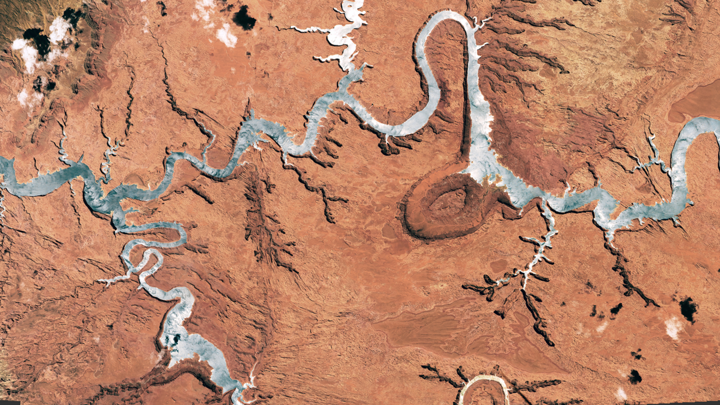 Une photo satellite montrant un réservoir géant semblable à une rivière qui a été transformé en argent par une lueur solaire.