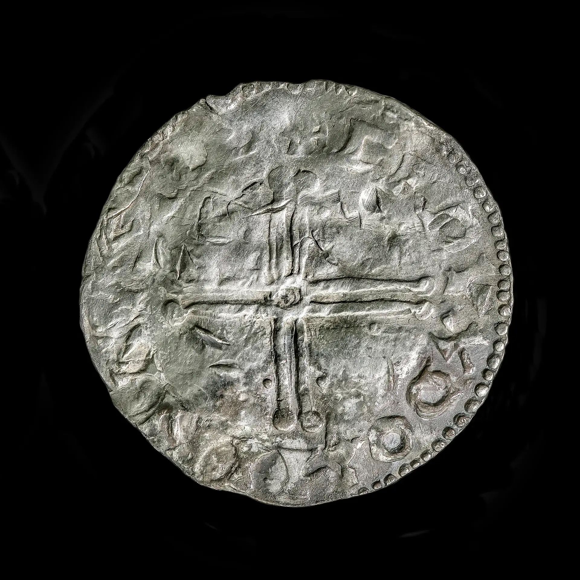 Un gros plan d'une pièce d'argent montrant une croix